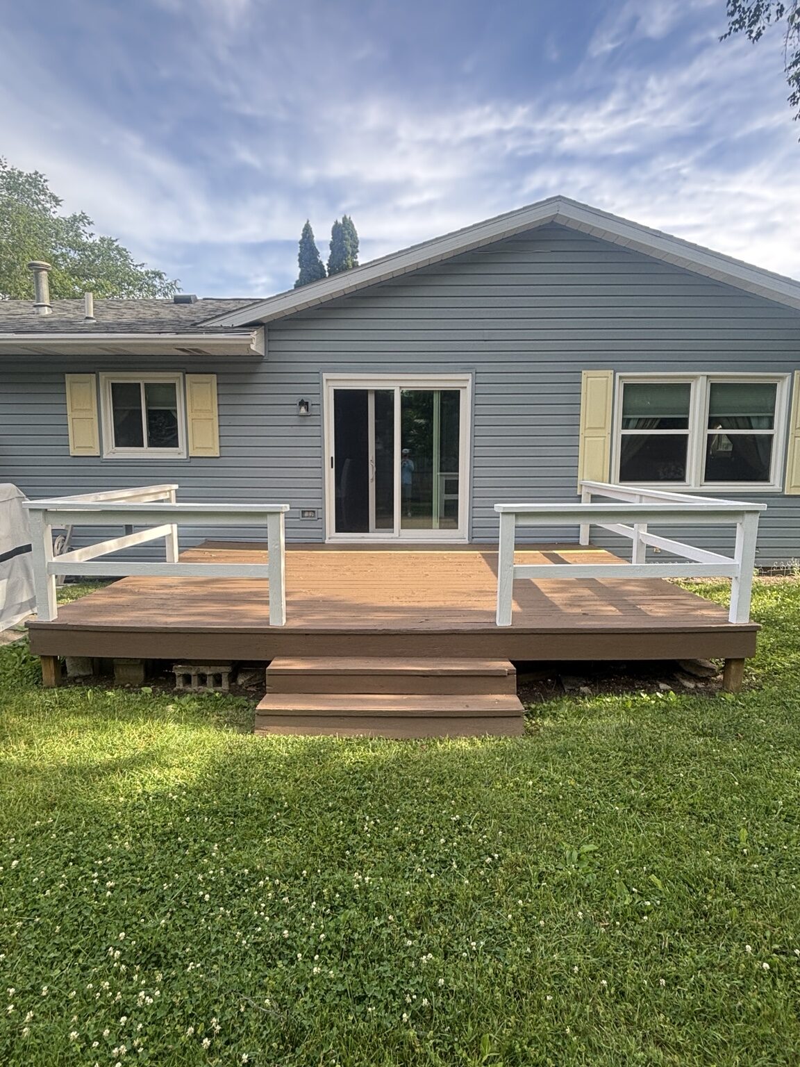 Finished backyard deck with warm brown boards and light gray railings