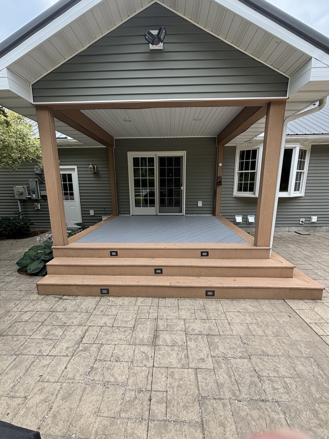 Finished covered patio deck with gray boards and warm wood-tone steps