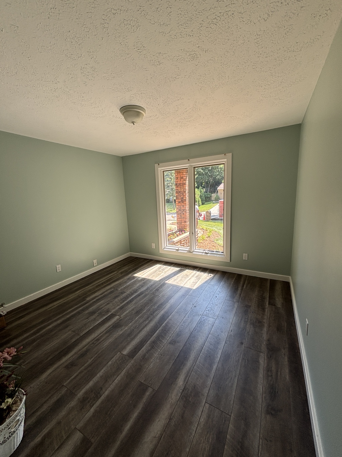 Finished sage green bedroom with bright white trim