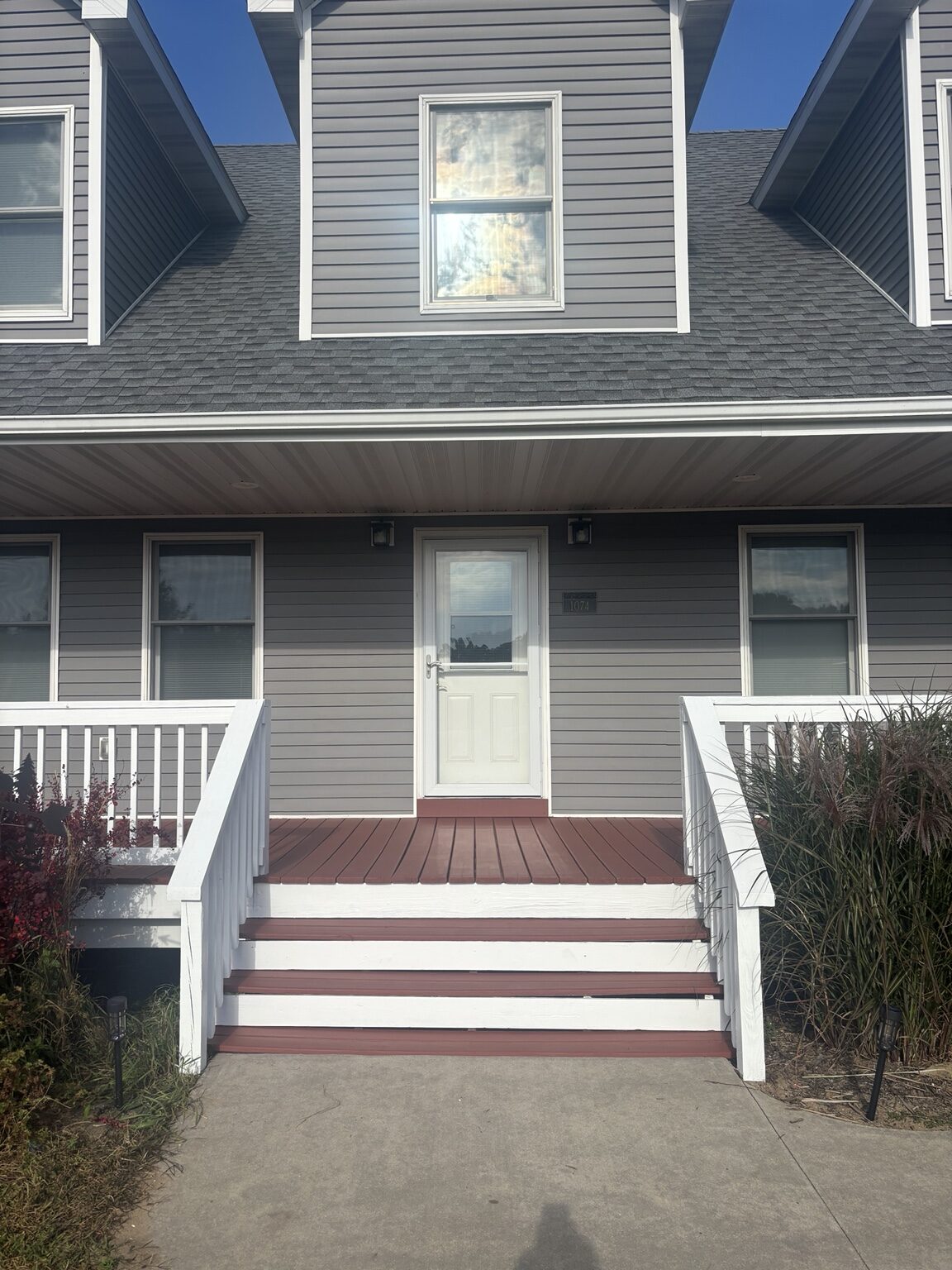 Finished red front porch and steps with crisp white railings